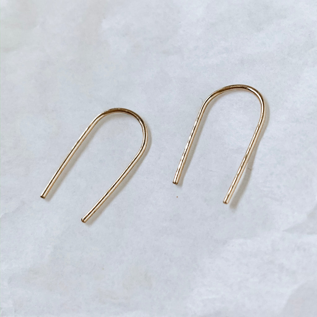 Minimal u-shaped arc earrings. Gold filled wire lightly hammered and shaped in Colorado. White background