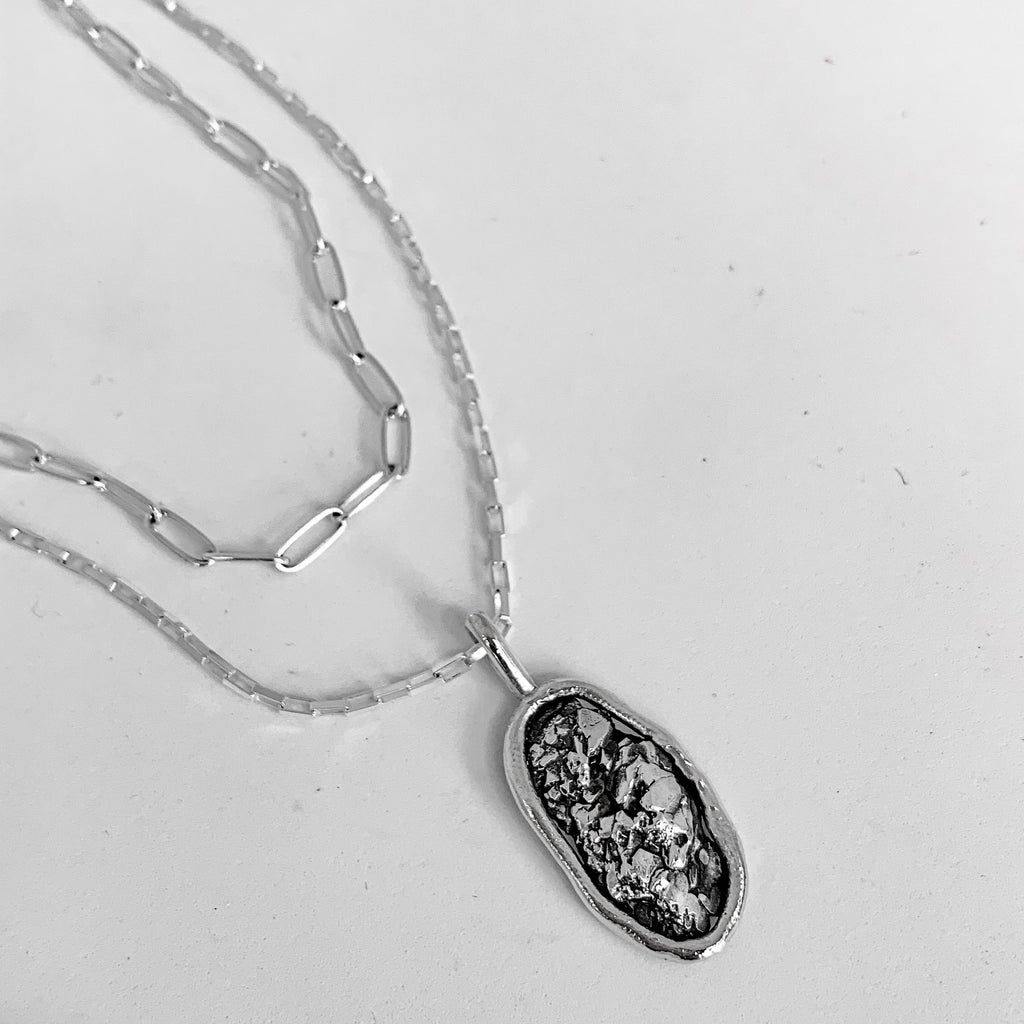 Crystal inspired handmade silver necklace on a layered silver chain with a white background